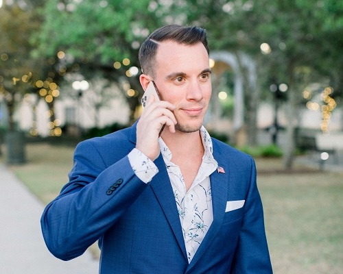 a man in a blue suit talking on his cell phone